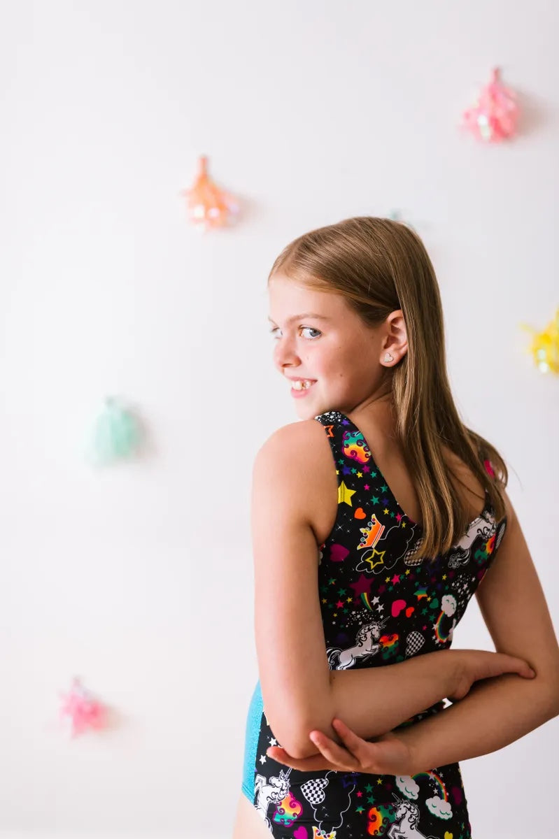 Red head young girl wearing a black and multi pattern gym leotard made by Girl Power Sports.